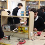 Students working on electronics projects in a lab, focusing on practical learning.